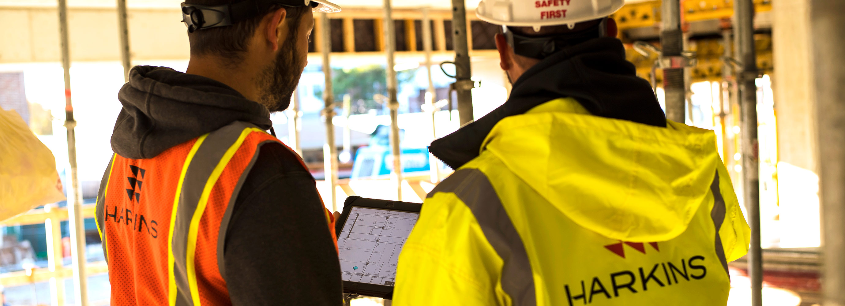 construction workers look over tablet of information