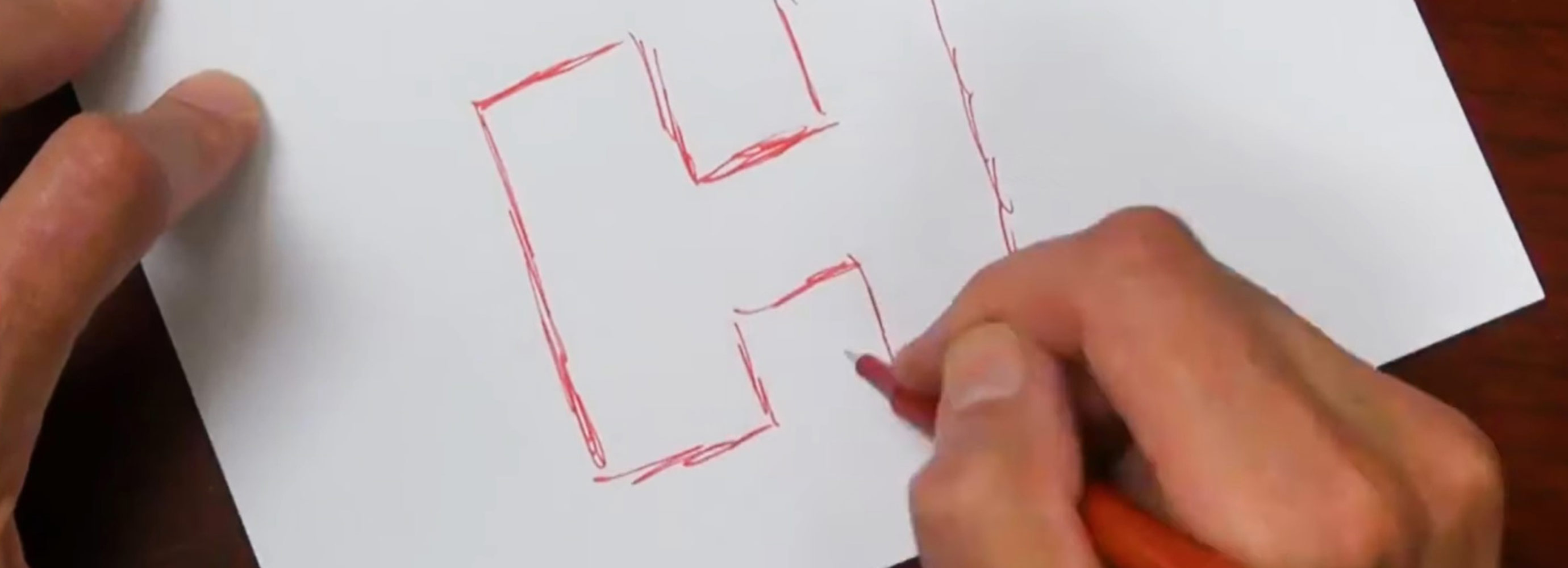 Person sketching logo on paper