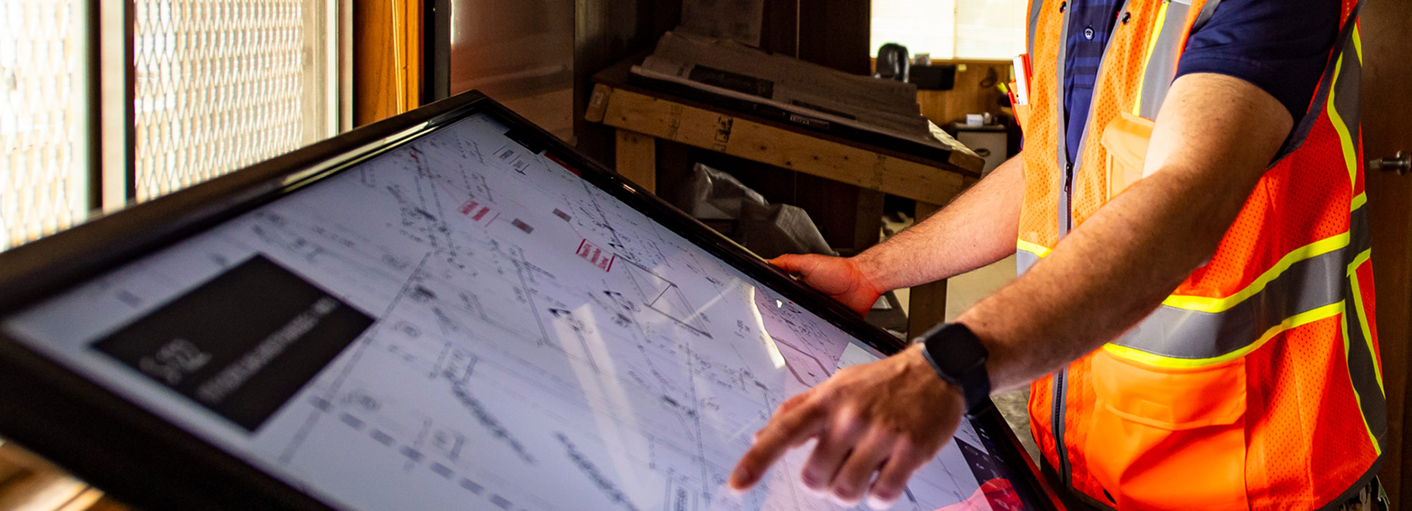 Employee pointing at digital plan table