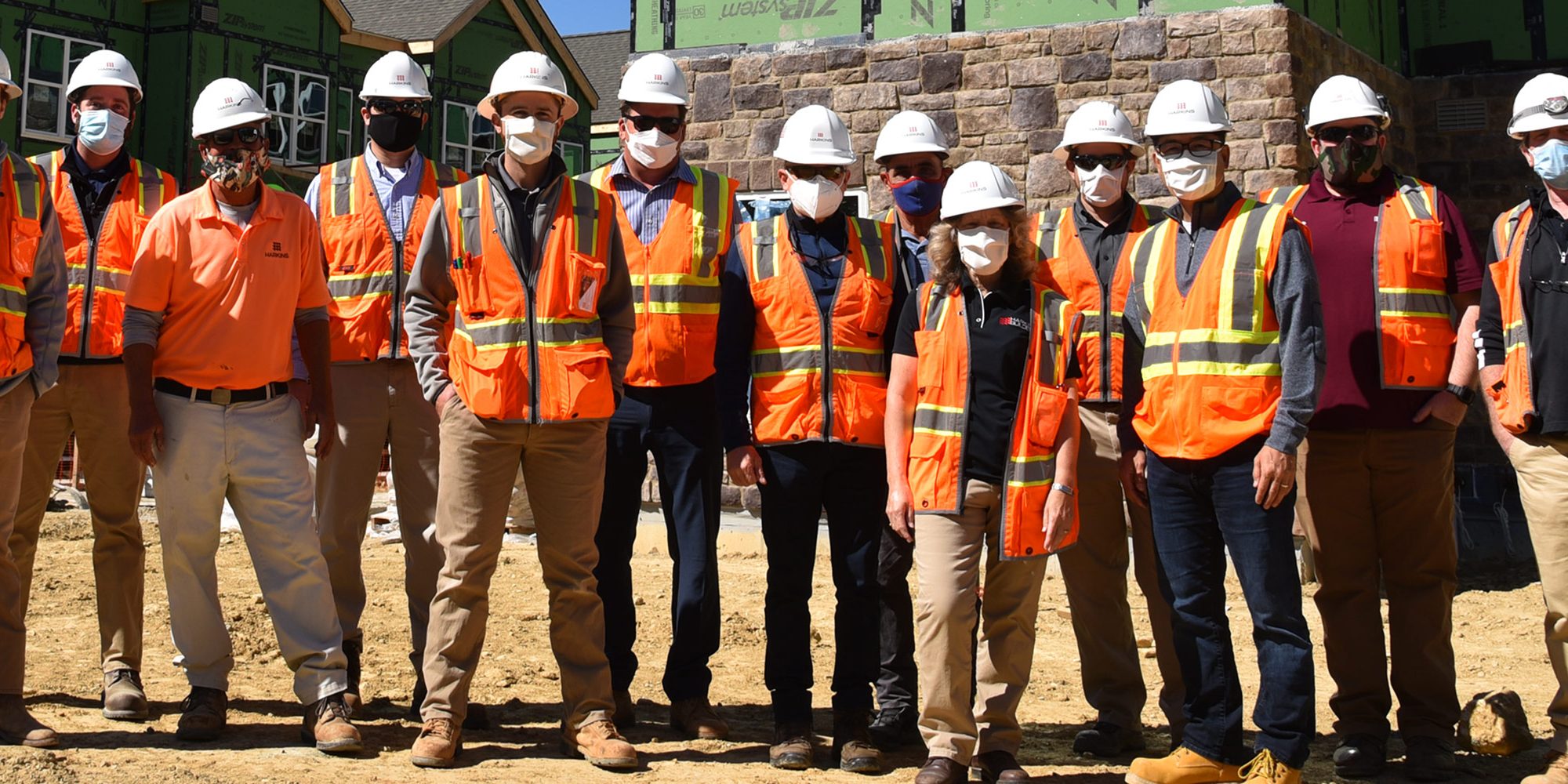 Homes at Fountain Green team standing in front of topped out buildings