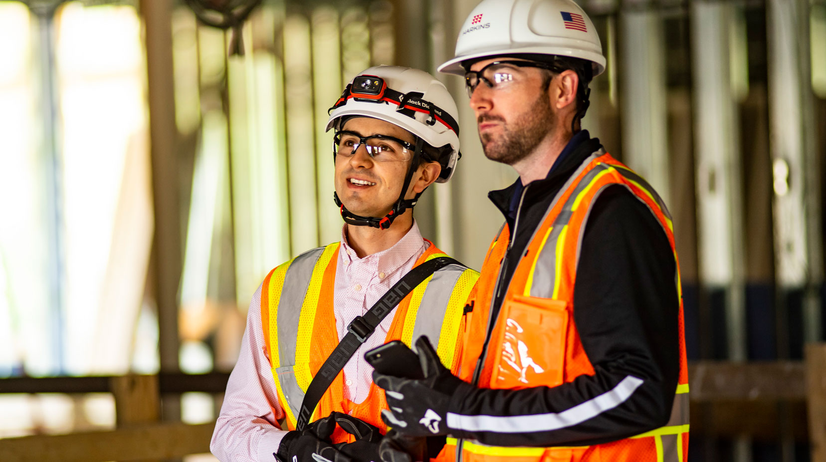 Two construction workers standing on build site.